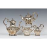 A Victorian silver three-piece tea set of lobed baluster form with floral finials above engraved