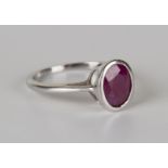 An 18ct white gold ring, collet set with an oval cut ruby, detailed 'Iliana', ring size approx N.