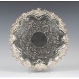 A large Victorian silver circular salver, the centre engraved with foliate scrolls, the raised