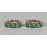 A pair of 9ct gold, emerald and diamond earrings, each mounted with four oval cut emeralds