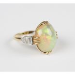 A gold, opal and diamond ring, claw set with the oval opal between princess cut and circular cut