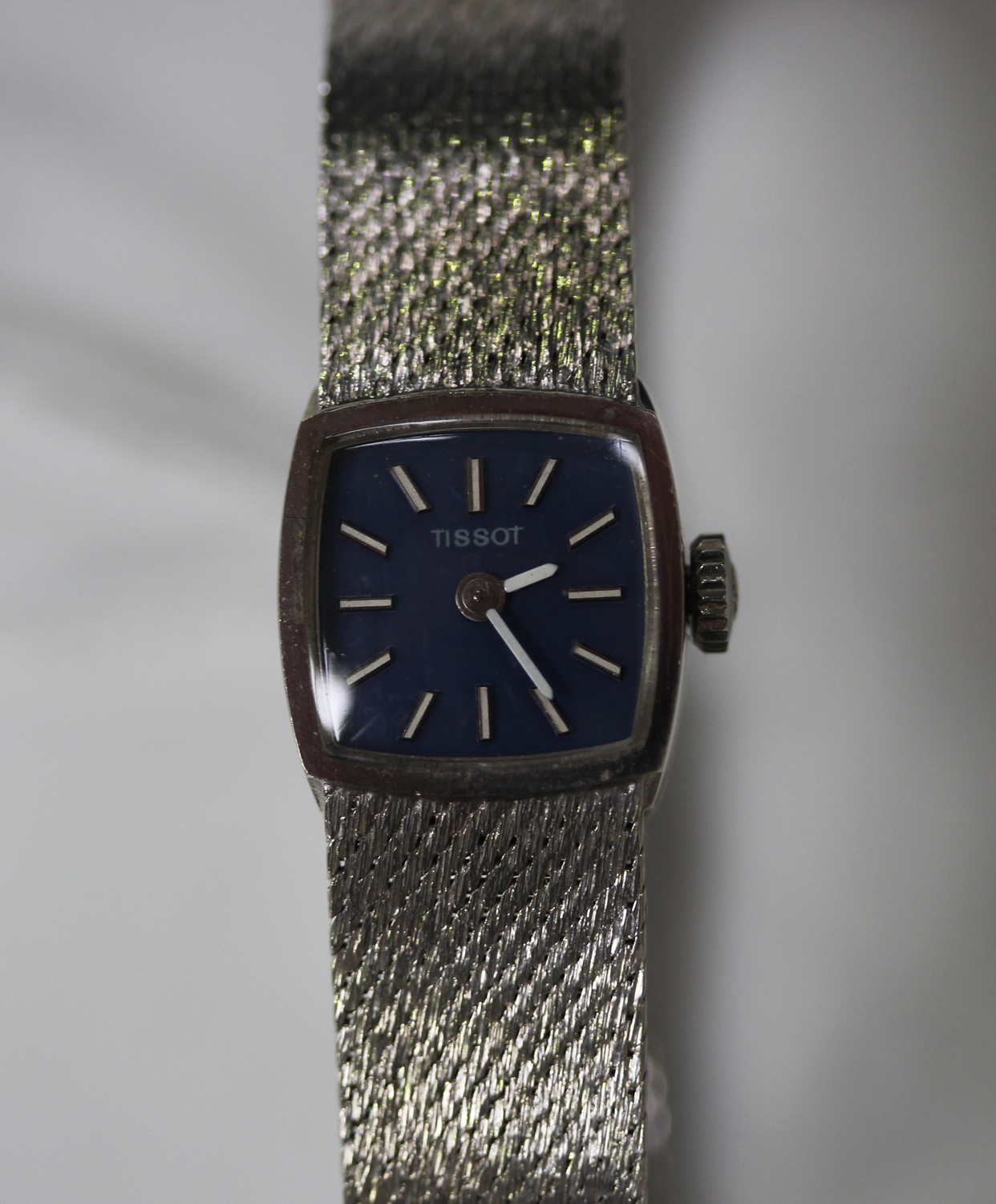 A Tissot 9ct white gold lady's bracelet wristwatch, the curved square blue dial with baton hour