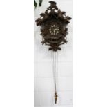 A late 19th/early 20th century Black Forest carved softwood cuckoo clock with weight driven movement