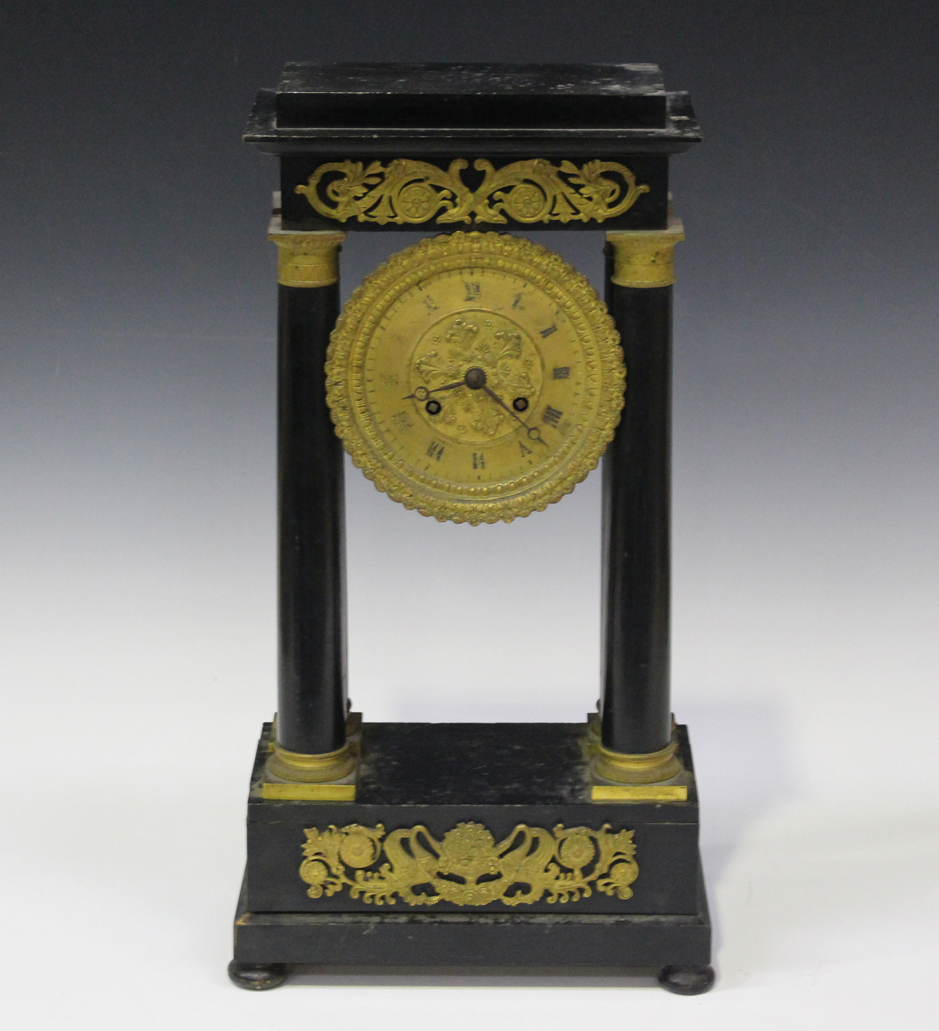 A mid to late 19th century French ormolu mounted ebonized portico mantel clock with eight day