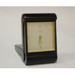 A black leather folding bedside alarm clock with eight day movement, the silvered rectangular dial