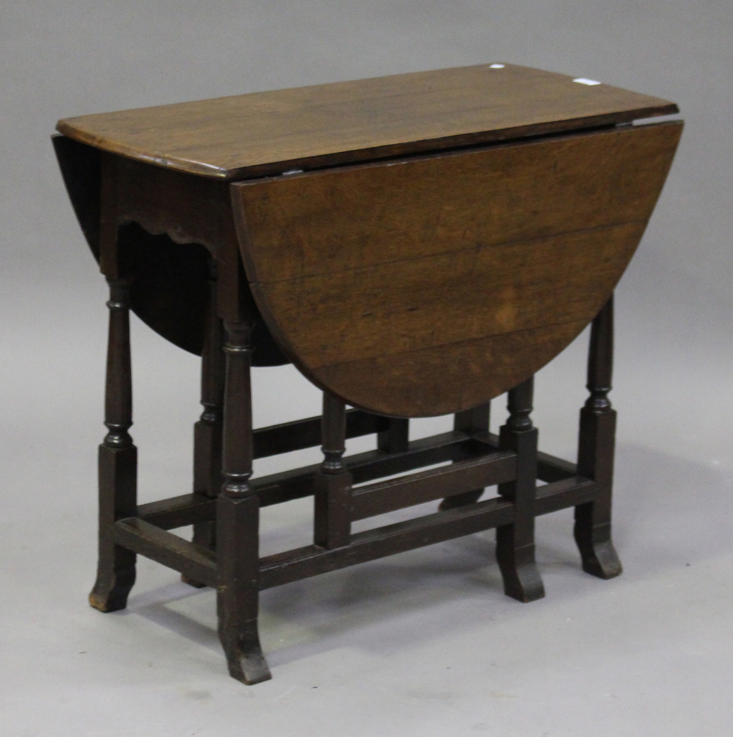 An 18th century oak oval gateleg supper table, on turned and block legs with outswept feet, height