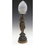 A late 19th century brown patinated cast bronze figural table lamp, later fitted with a cut glass