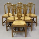 A set of six George III provincial walnut pierced splat back dining chairs, inset with rush seats,