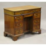 An early 19th century mahogany kneehole desk, the hinged lid revealing a writing surface, above an