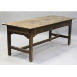 A 19th century oak farmhouse kitchen table, fitted with a single end drawer, raised on block legs