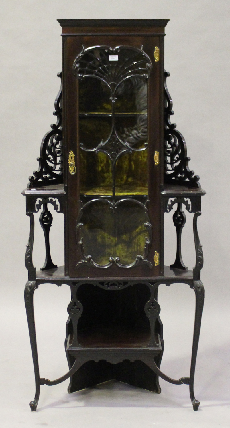 An Edwardian mahogany corner display cabinet with pierced scroll decoration, fitted with a single