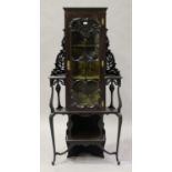 An Edwardian mahogany corner display cabinet with pierced scroll decoration, fitted with a single