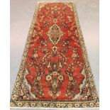 A Hamadan runner, North-west Persia, mid-20th century, the red field with a lozenge medallion,