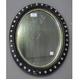 A 19th century Irish ebonized oval wall mirror, the frame inset with glass squares, 46cm x 35cm.