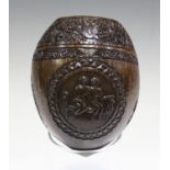 A 19th century carved coconut, finely worked with a band of birds and foliage above three reserves