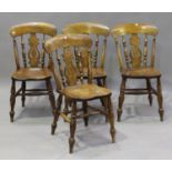 A set of four early 20th century beech and elm Windsor dining chairs, the solid seats raised on