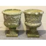 A pair of 20th century cast composition stone garden urns, the half-reeded bodies with flowerhead