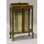 A 20th century Queen Anne style walnut display cabinet, fitted with a pair of astragal glazed doors,