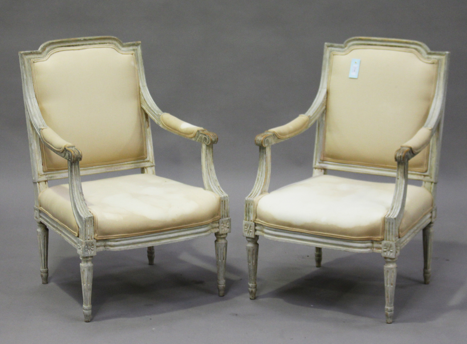 A pair of 20th century Louis XVI style grey painted fauteuil armchairs, the overstuffed seats and