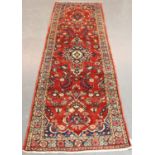 A Hamadan runner, North-west Persia, mid-20th century, the red field with a shaped medallion,