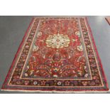 A Hamadan rug, North-west Persia, mid-20th century, the red field with a shaped ivory medallion,