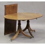 A 19th century George III style mahogany D-end dining table with single extra leaf, raised on turned