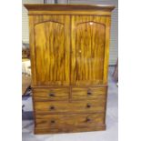 An early Victorian figured mahogany linen press, the angular pediment above a pair of arched panel