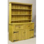 A 20th century pine dresser, the shelf back above two drawers and cupboards, height 217cm, width