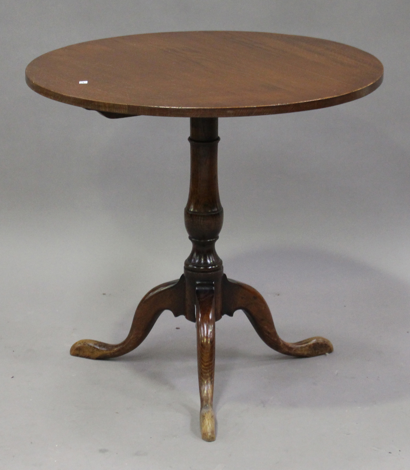 A 20th century George III style oak circular tip-top wine table, the turned column on tripod