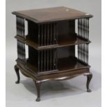 An Edwardian mahogany revolving library bookcase, the gadrooned serpentine top above turned