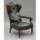 A 19th century French mahogany and buttoned green leather wing back armchair with carved foliate