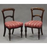 A set of eight mid-Victorian mahogany spoon back dining chairs, the overstuffed seats raised on