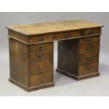 An Edwardian oak twin pedestal desk, fitted with eleven drawers, on plinth bases, height 74cm, width