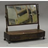 A late George III mahogany swing frame toilet mirror, the base fitted with three drawers, on