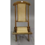 An early 20th century beech framed folding steamer chair with caned seat and back, height 89cm,