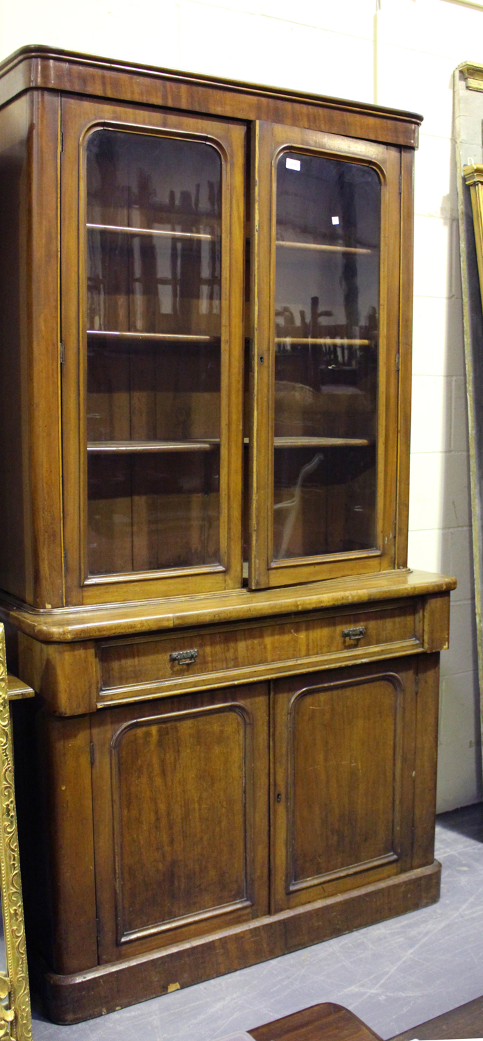 A Victorian mahogany bookcase cabinet, fitted with a pair of arch glazed doors above a single frieze