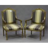 A pair of early/mid-20th century Louis XVI style giltwood fauteuil armchairs, the overstuffed