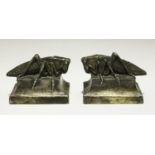 A pair of Art Deco plated copper-cased bookends, each modelled as a locust on a shaped pedestal,