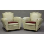 A pair of French Art Deco 'Moustache' club armchairs, upholstered in cream leatherette, on block