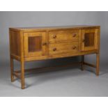 An early 20th century oak sideboard by Heals, the chamfered top above two drawers flanked by