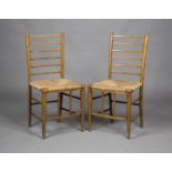 A pair of Edwardian Arts and Crafts stained beech rail back bedroom chairs with rush seats and