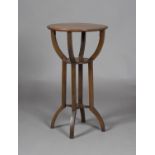An Edwardian Arts and Crafts walnut circular three-tier occasional table, in the manner of J.S.