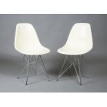 A pair of modern Eames 'DSR' chairs, the cream moulded plastic seats raised on chromium plated '