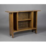 An early 20th century Arts and Crafts style oak open bookcase, the inverted breakfront top above