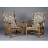 A pair of early 20th century Arts and Crafts oak framed armchairs, in the manner of Shapland &