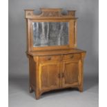 An Edwardian Arts and Crafts oak sideboard, the mirror back with pierced side supports and carved