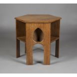 An early 20th century Arts and Crafts oak hexagonal book table, three sides pierced with teardrop