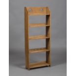 An Edwardian Arts and Crafts oak five-tier open bookcase, the gallery back pierced with two inverted