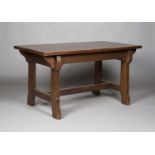 An early 20th century Arts and Crafts stained oak rectangular centre table, raised on shaped