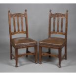 A pair of Edwardian Arts and Crafts walnut framed side chairs, the carved bar and pierced splat